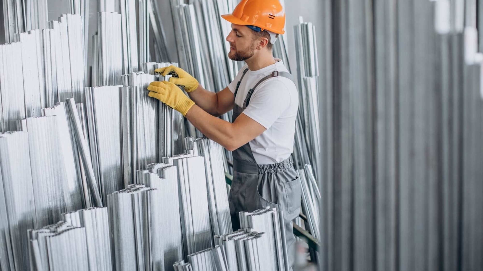 Pracownik w pomarańczowym kasku w magazynie