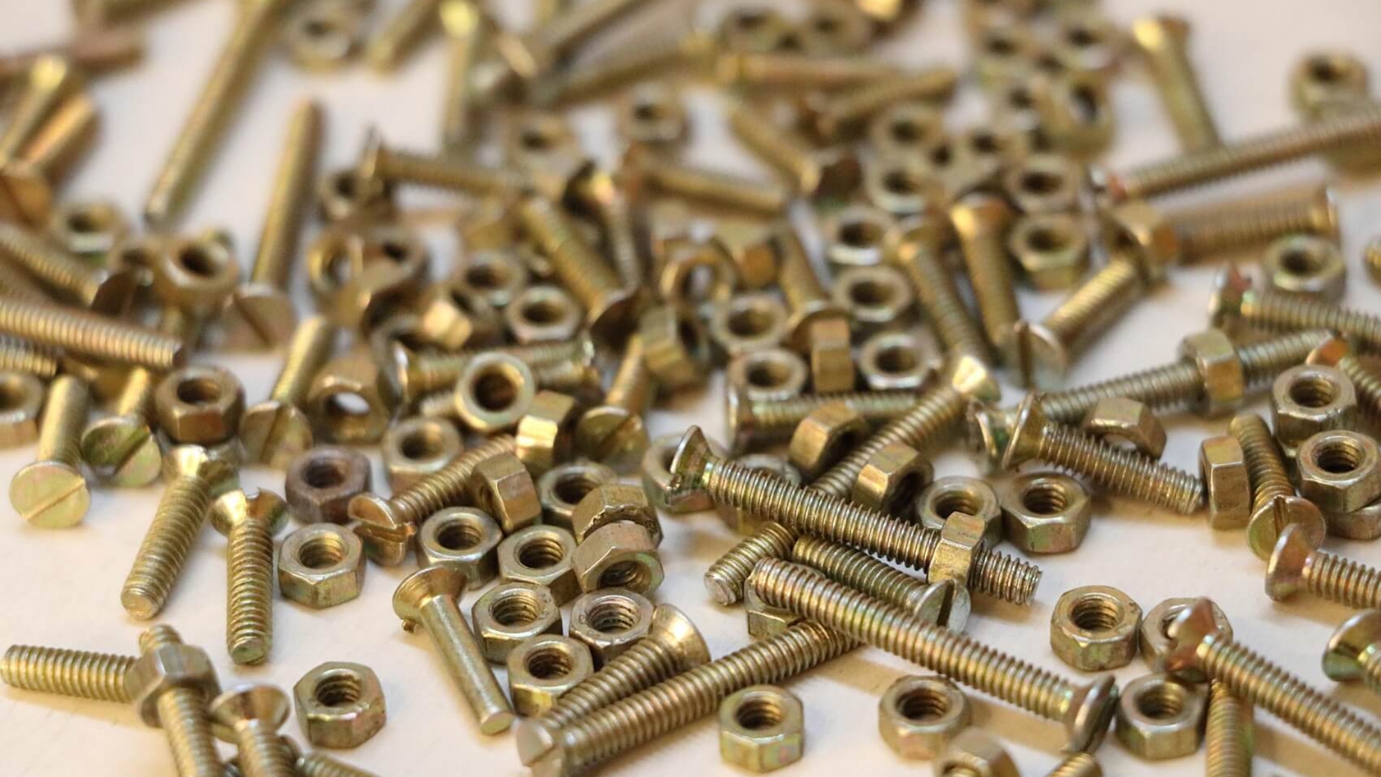 Metalowe śruby i nakrętki na białym tle